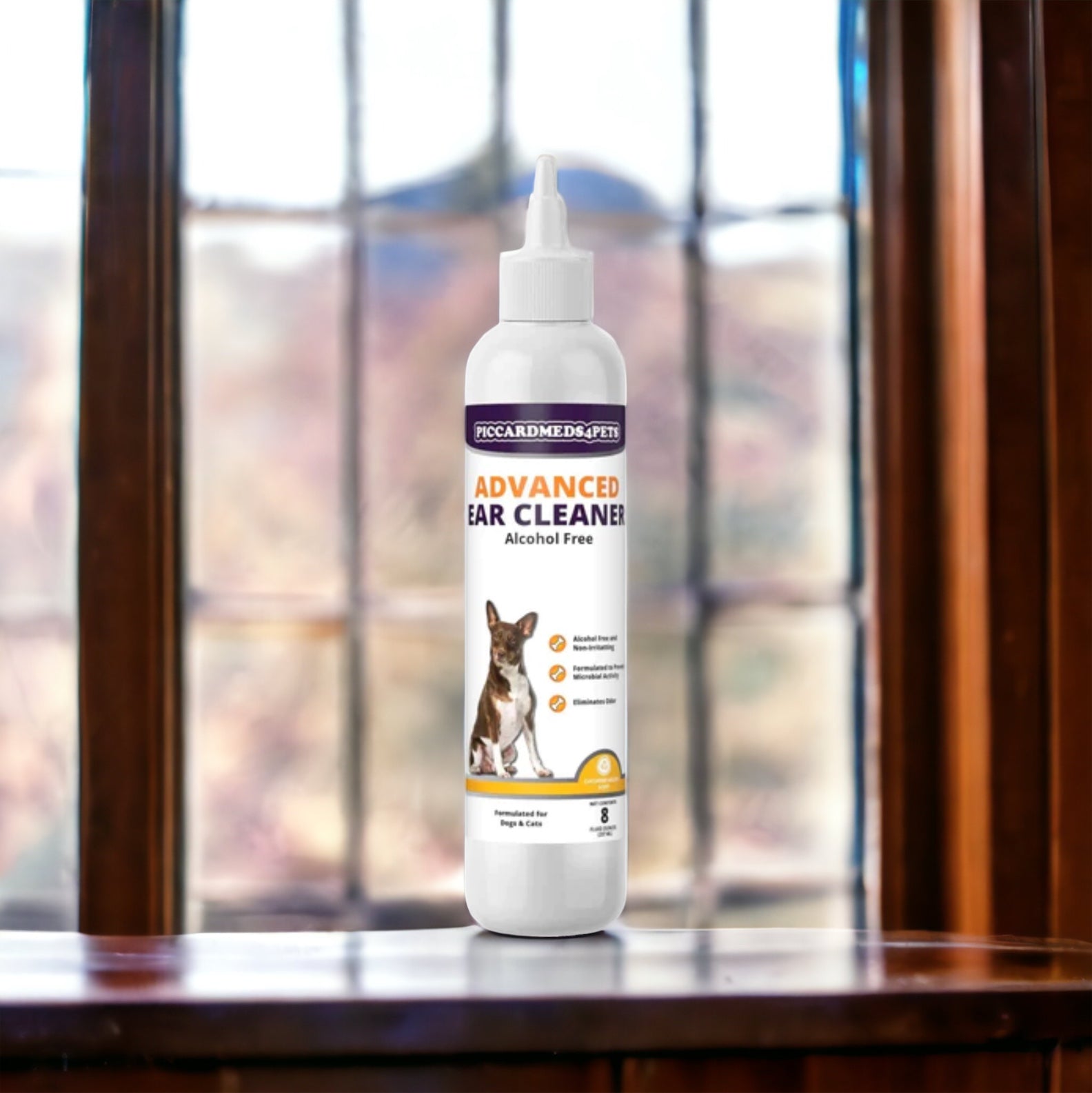 Bottle of Piccard Medi-Pets Advanced Ear Cleaner on a wooden surface with a window in the background
